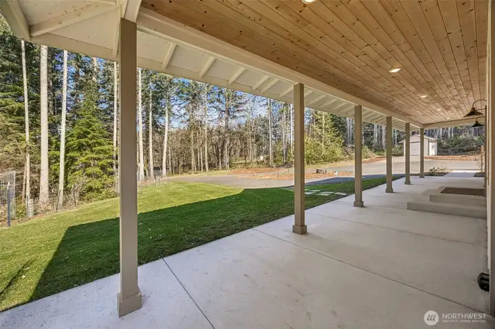 Welcoming covered front porch & patio. Relax and enjoy your beautiful private property! Building to the right is the pump house for well with room to store things.