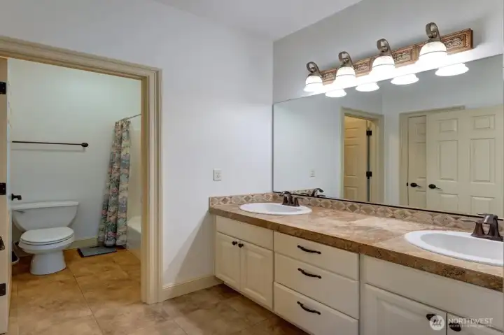 Upstairs bathroom services two guest bedrooms. Double sinks.