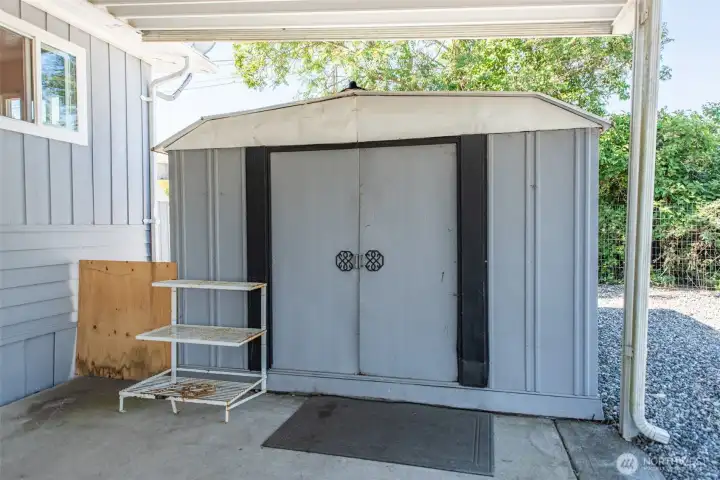 Shed in carport with shelving inside. Shed in carport with shelving inside.