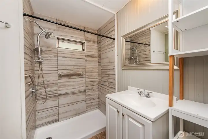 Main bathroom with ceramic tile walk in shower, with safety grab bars. Main bathroom with ceramic tile walk in shower, with safety grab bars.