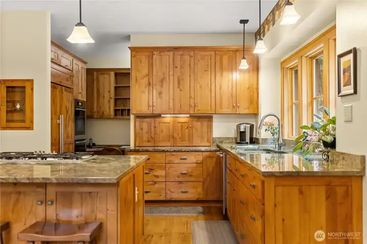 Gorgeous kitchen with custom cabinets, green-granite counters, sub-zero fridge, double ovens, propane Miele range, office nook and large walk-in pantry.