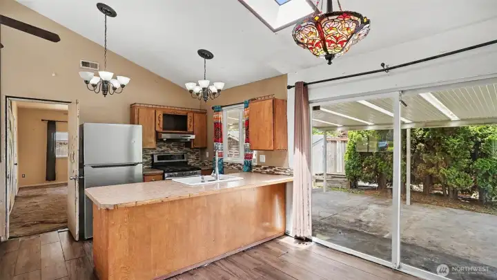 Adjacent to the kitchen, the dining area features a large sliding door that opens to the backyard, providing seamless indoor-outdoor living.