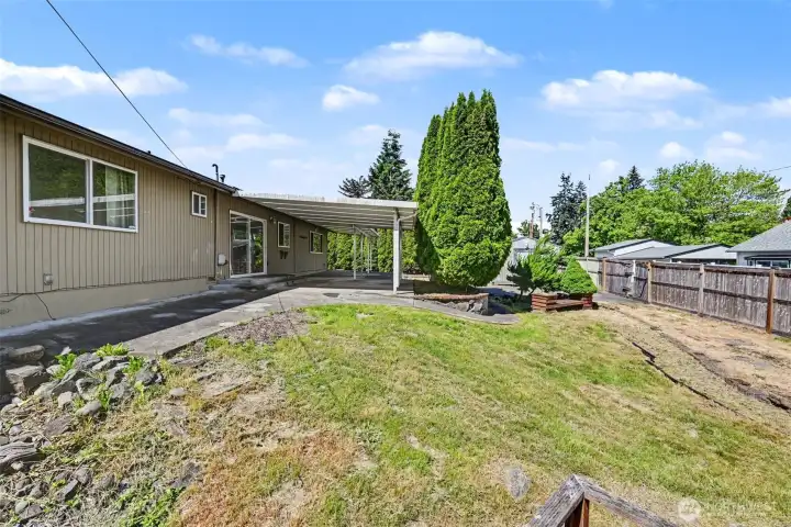 Mature landscaping and tall privacy hedges create a peaceful setting perfect for relaxing or entertaining.