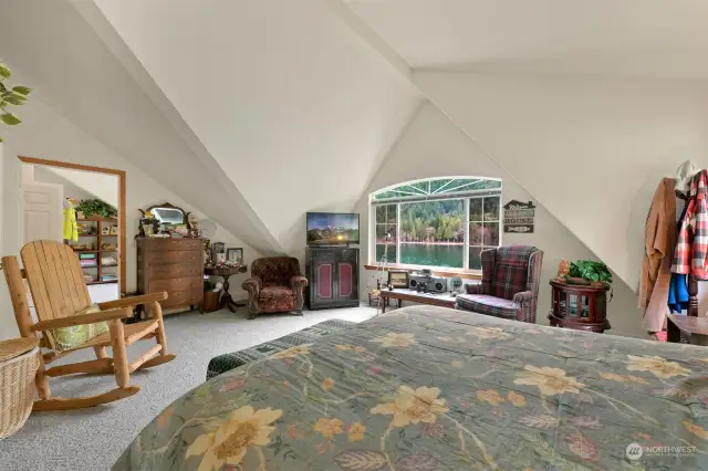 Spacious primary bedroom with lots of natural light and stunning view looking over the lake.