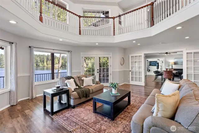 Living area with views of the lake, french doors to the deck and oversided french doors to the dining room beyond.