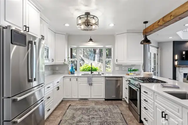 Kitchen offers plenty of cupboard space, stainless fridge.