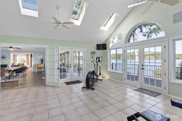 Large flex room with ceiling fan, skylights and french doors to the deck and lake views. Currently used as a home gym.