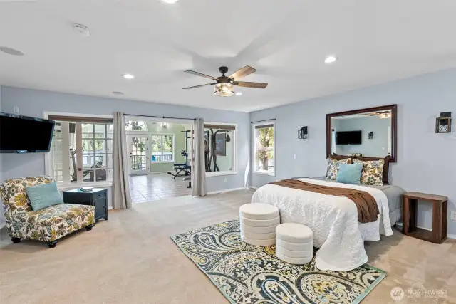 Primary suite  with in room sink vanity and french doors to the flex space with the lake beyond.
