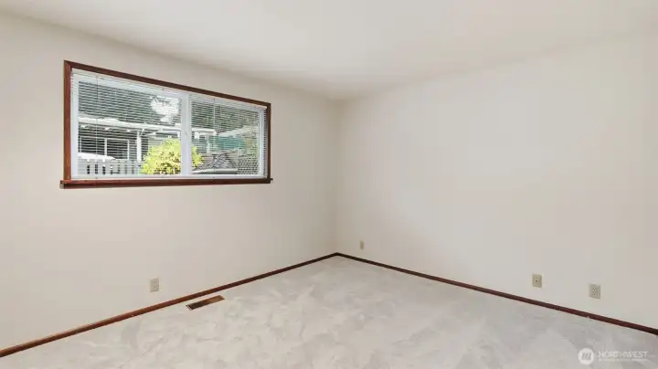 Light-filled primary bedroom with neutral finishes ready for your ideal setup.