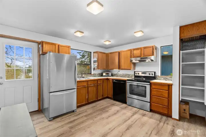 Large kitchen with stainless steel appliances and ample storage space.