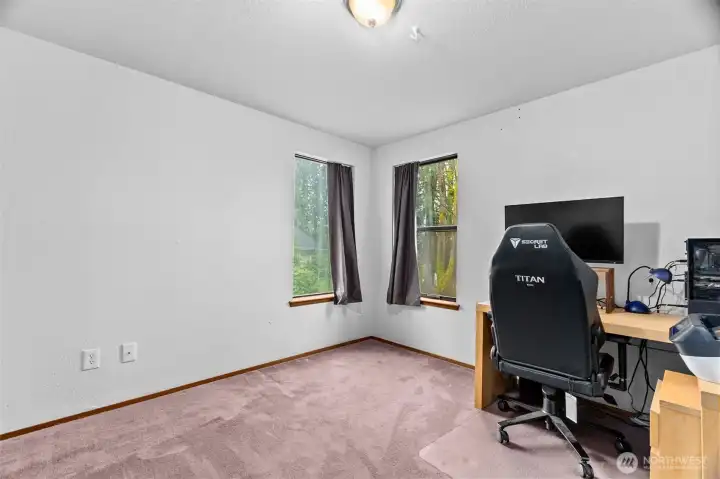 Downstairs bedroom, currently being used as an office.  Corner windows offer green views.