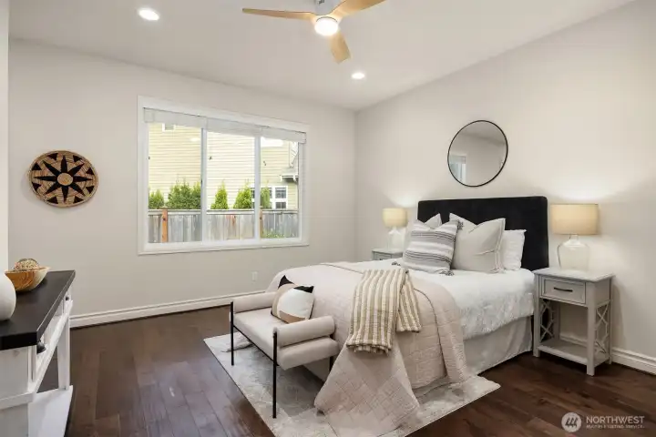 A main level guest suite (bedroom #1) with a full bathroom is perfect for multi-generational living - providing comfort and privacy. Enjoy a custom-designed closet system for elevated organization, wide-plank hardwood flooring, ceiling fan for added comfort.