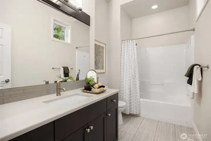 Main-level full bath adjoining the guest suite offers effortless convenience and versatile functionality for both guests and everyday living.