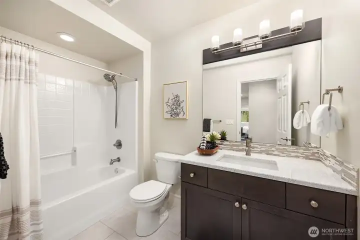 Upper level full bathroom with slab quartz and undermount sink offers privacy and convenience.