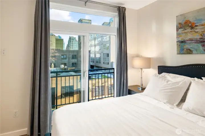 With a slider out to the balcony, you can wake to morning sun or wind down to twinkling city lights outside. With a slider out to the balcony, you can wake to morning sun or wind down to twinkling city lights outside.