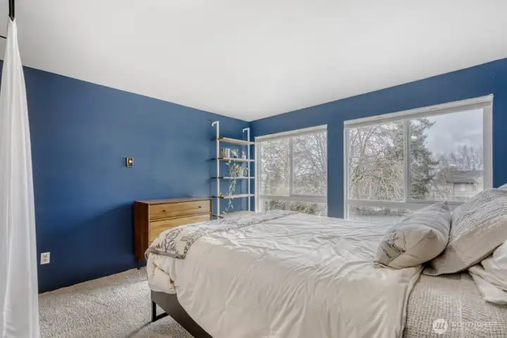 Primary bedroom bathed in natural light, and with an Olympic Mountain view.