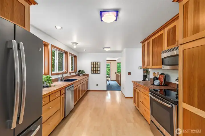 This kitchen is so warm, inviting and well-updated: laminate flooring, two tone, solid cabinetry including some tall pull-out drawers, tile touches and newer stainless stell appliances. This kitchen is so warm, inviting and well-updated: laminate flooring, two tone, solid cabinetry including some tall pull-out drawers, tile touches and newer stainless stell appliances.