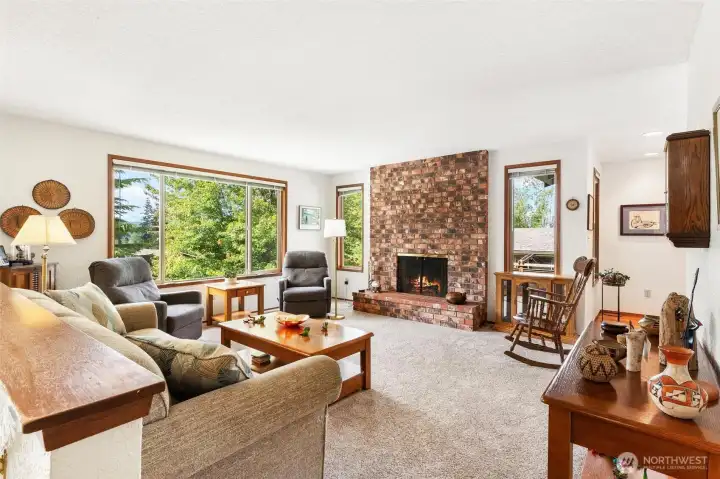 Bright, spacious living room featuring a cozy floor-to-ceiling brick fireplace. Bright, spacious living room featuring a cozy floor-to-ceiling brick fireplace.