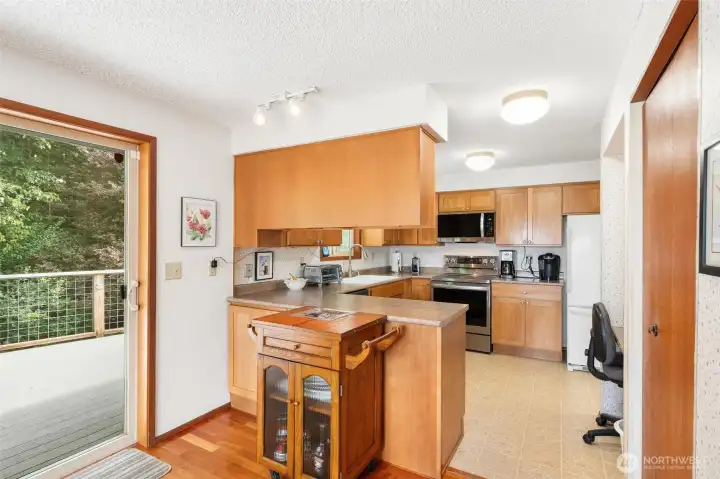 Clean, functional kitchen with a view of the lush backyard and direct deck access. Clean, functional kitchen with a view of the lush backyard and direct deck access.