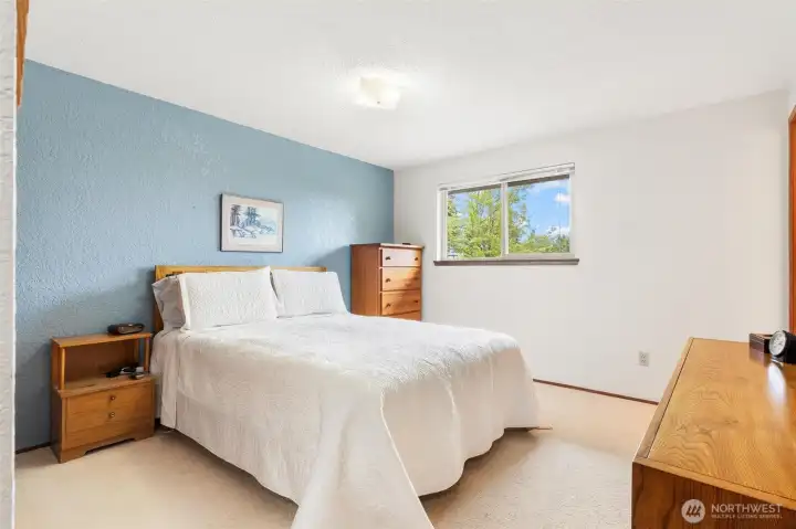 Third bedroom with a tasteful accent wall and views of the yard. Third bedroom with a tasteful accent wall and views of the yard.