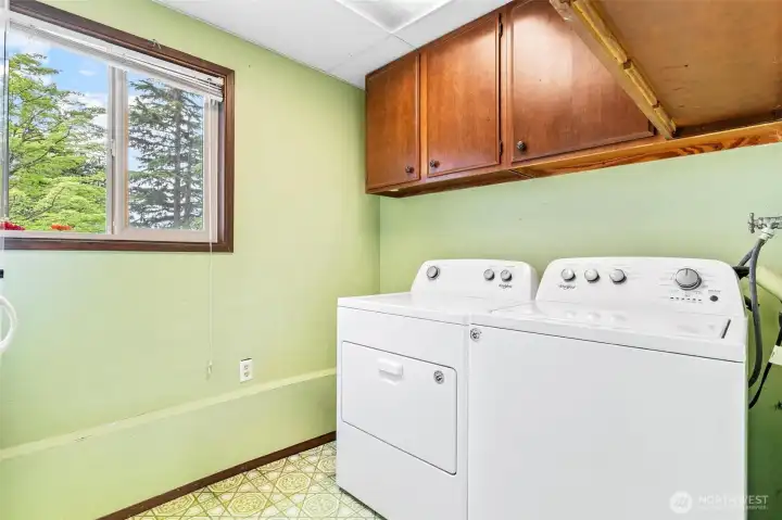 Dedicated laundry room with upper cabinets for extra organization. Dedicated laundry room with upper cabinets for extra organization.
