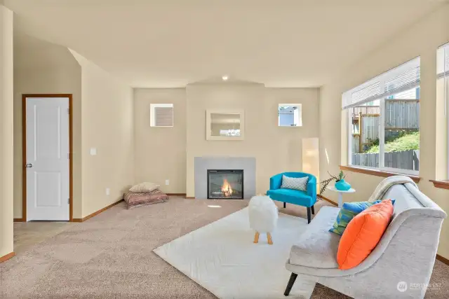 Bright and airy living room with gas fireplace and brand new carpets.