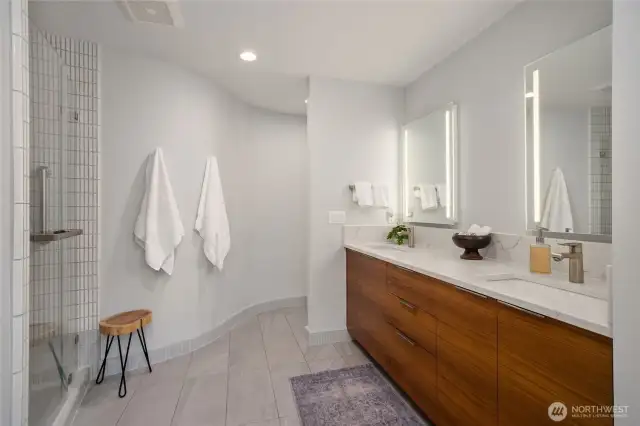 Remodeled bathroom with a curved shower and Anne Sacks tile...