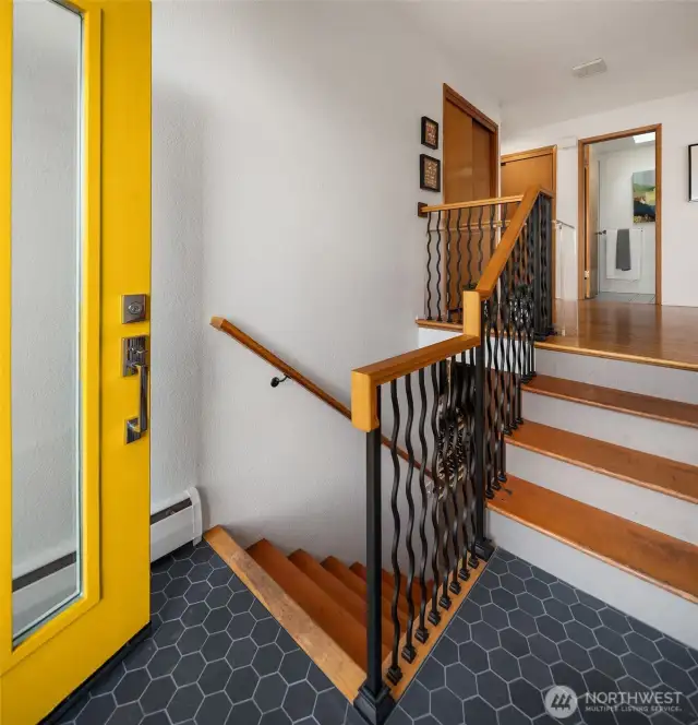 Tile entry with hardwoods and wrought iron railing lead you into the mojo
