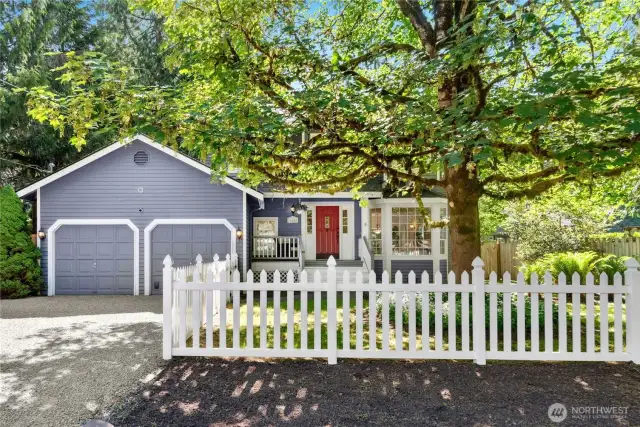 Large front yard with white picket fence and 2 car garage.