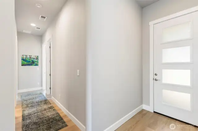 Front door and hallway to laundry room, two bedrooms and full bath