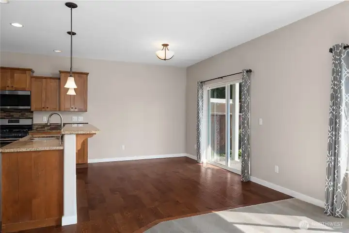 Kitchen with raised bar, pendant lighting, and dining area provides a spot for meals while the open layout makes for easy entertaining.