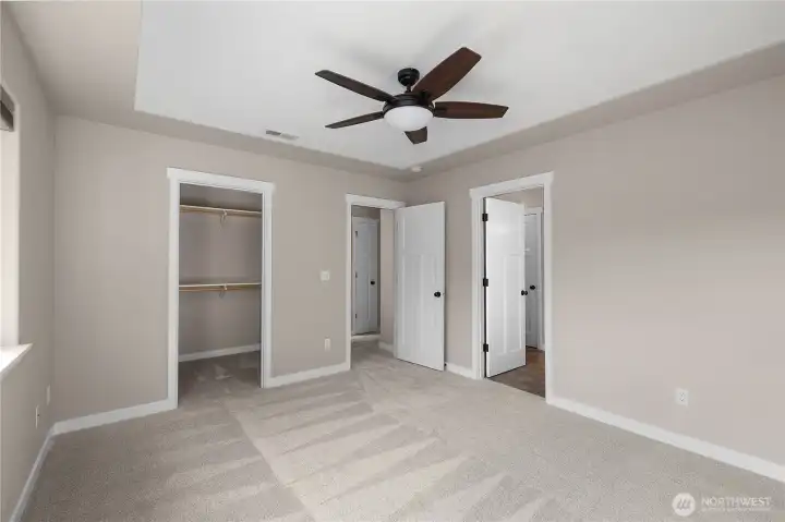 Primary suite features a 5-piece bath, walk-in-closet, ceiling fan, stylish ceiling detail, and brand new carpet.