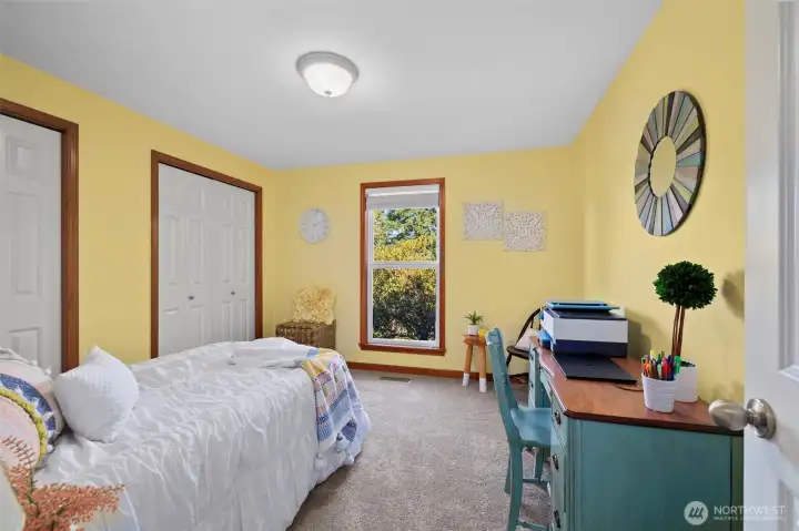 Spacious second bedroom with a large window that brings the outdoors in