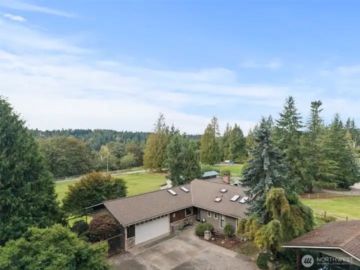A stunning overhead view showcasing the full home and beautifully landscaped backyard
