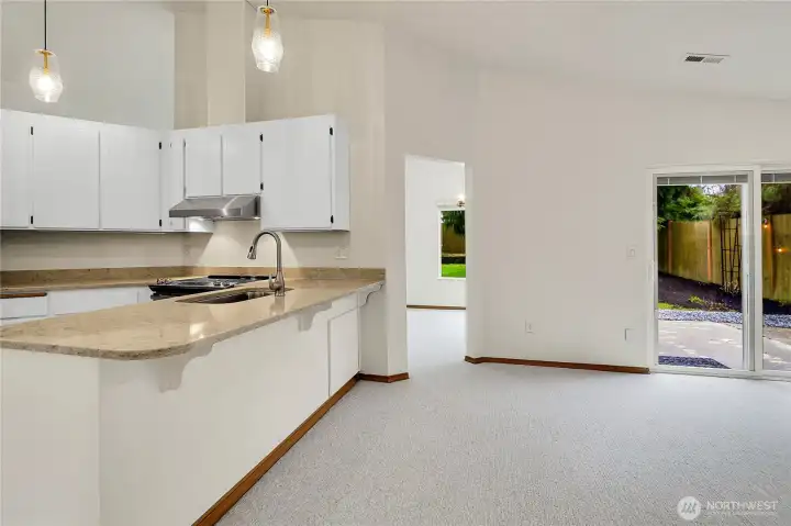 Living room off kitchen with gas fireplace and backyard access