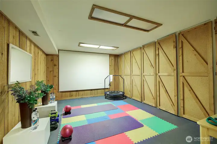 Imagine the possibilities here!  Rubber matting encourages a home gym...or...use the space as a home theater.  Wood doors open to multiple  storage closets.