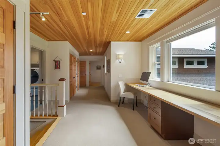 Generous upper hallway with custom built-in desk, offering additional workspace and functional everyday living.