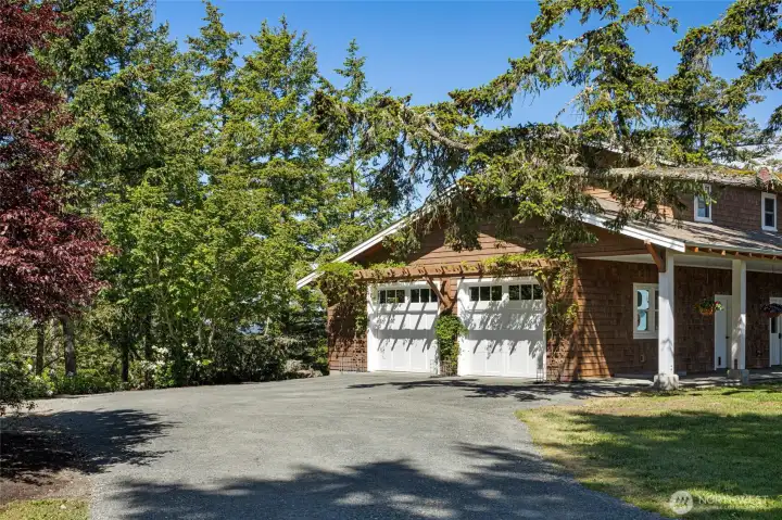 Detached garage with ample space for vehicles, storage, or workshop, surrounded by mature landscaping and natural island setting.