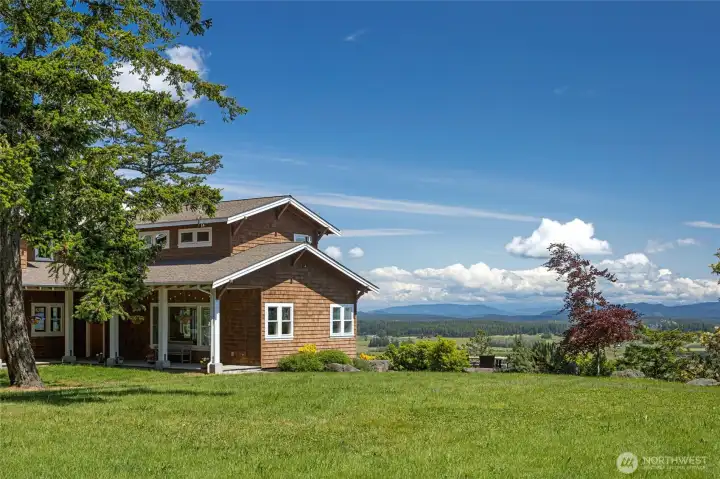 Beautifully sited home with expansive lawn, mature trees, and sweeping panoramic views across the island landscape.