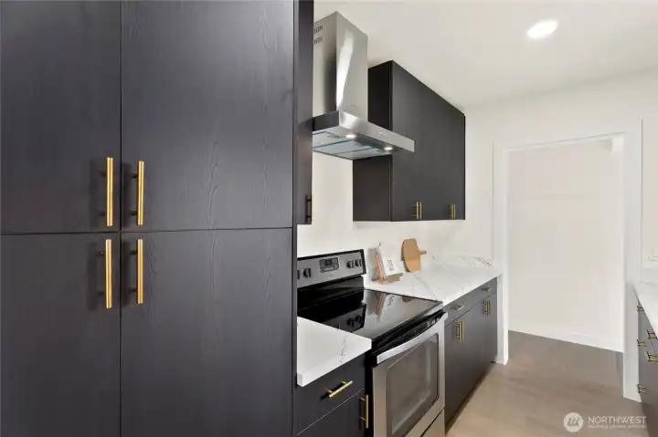 Modern kitchen with quartz counters, sleek cabinetry, and stainless steel appliances.