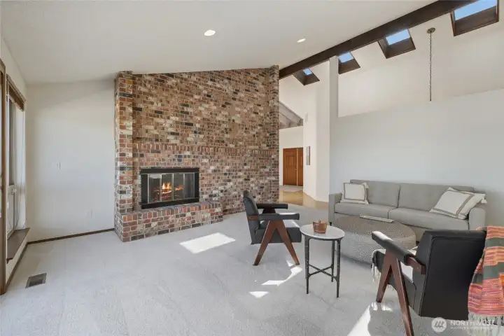 Wood burning fireplace and vaulted ceilings in the living room.