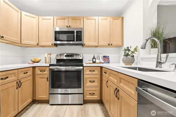 The kitchen has been completely refreshed with handsome new cabinetry, slab quartz countertops, and stainless-steel appliances, including a new refrigerator and dishwasher. The kitchen has been completely refreshed with handsome new cabinetry, slab quartz countertops, and stainless-steel appliances, including a new refrigerator and dishwasher.