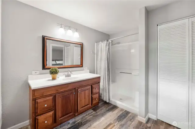 Primary bath has a two bench walk-in shower and ample storage.