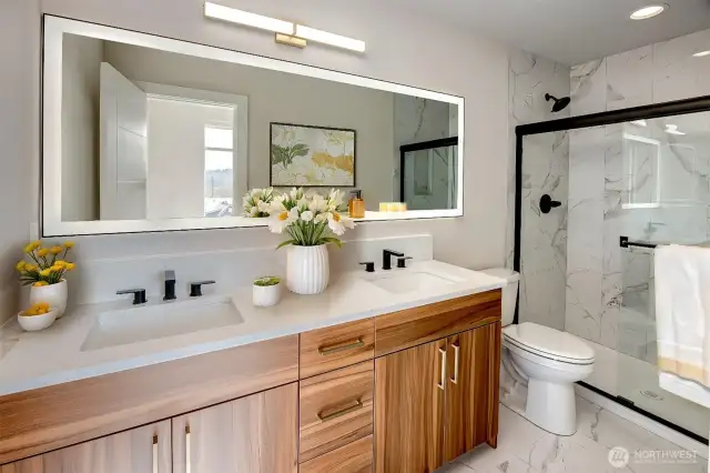 Glass Paned Shower In Primary Bathroom Featuring New Lighting And Full Sized Mirror  Virtually staged