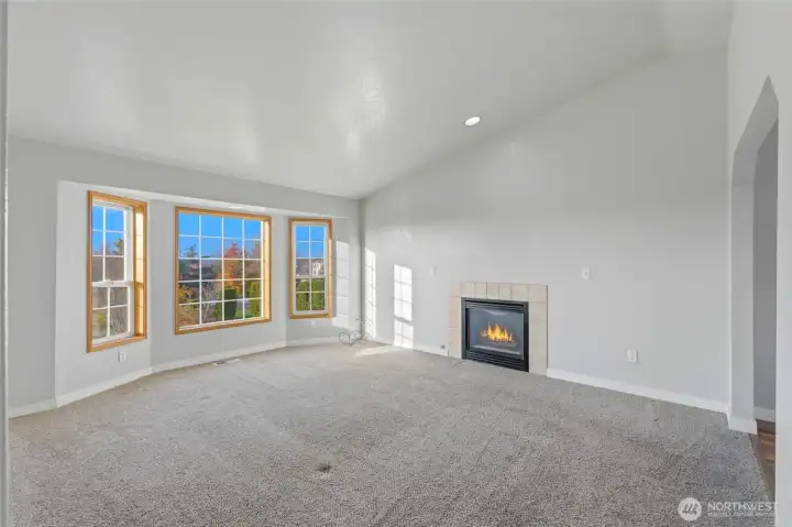 Upper living room with newer carpet, trim, vaulted ceilings & gas fireplace.