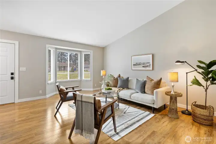 The front door leads to this spacious living room with vaulted ceiling and bay window.