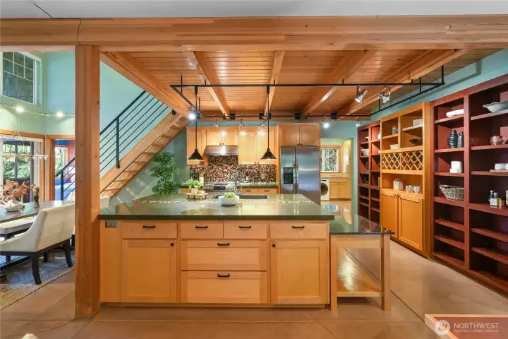 View of kitchen from home office,  Laundry room and garage access in back off to the right.  Dining room and primary bedroom on the left.
