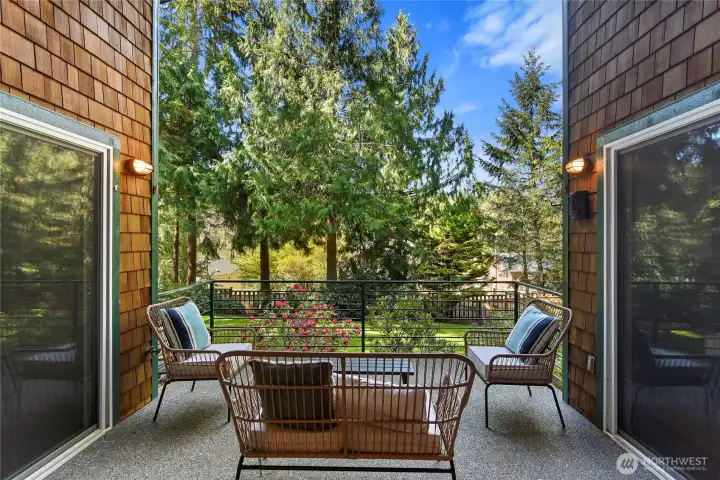 Main floor covered deck overlooking fenced and lush side yard.