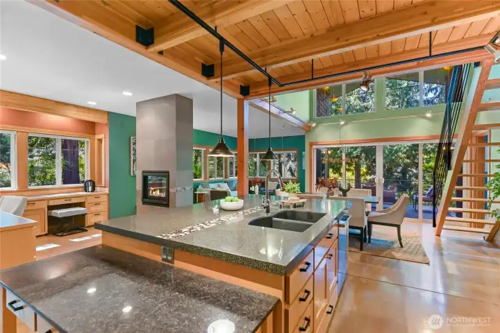 Kitchen looking out to home office, living room, dining room, and stairs to loft above.