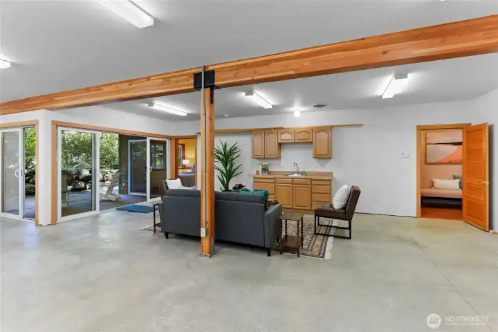 Center post has 2 x 220v receptacles wired to the daylight basement subpanel for optional separate shop use.  The door to the right leads to the bathroom and the stairs to the main floor.  Bedroom #2 with patio access is left of the pole.